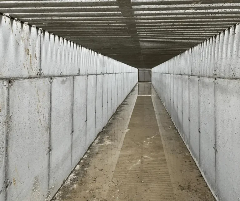 Widok wewnątrz wykonanego kanału betonowego stanowiącego część infrastruktury obiektu gospodarczego.