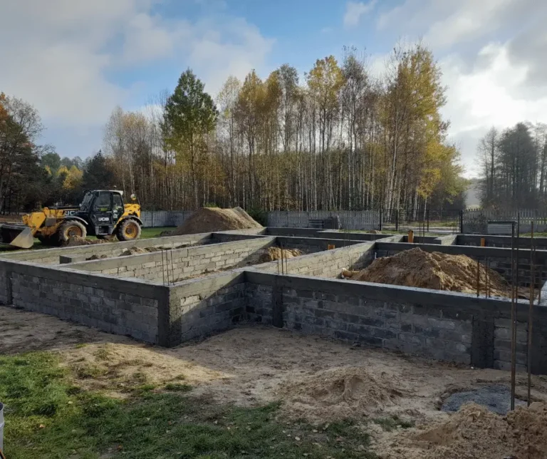 Etap budowy obejmujący wykonanie ścian fundamentowych i przygotowanie pod kolejne prace konstrukcyjne.