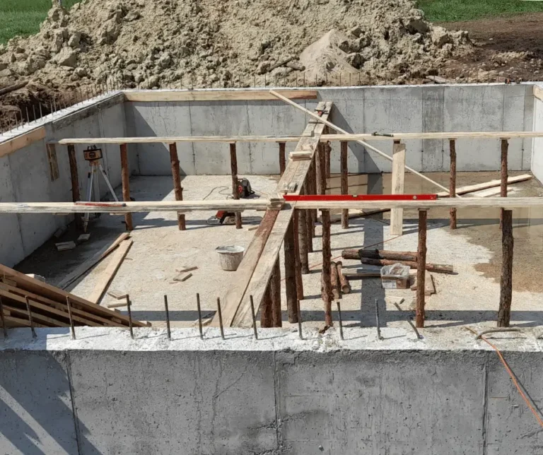 Ściany żelbetowe w trakcie budowy z przygotowanym podparciem konstrukcji